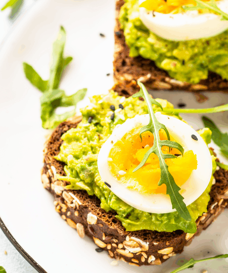 Avocado-Toast mit Ei und Rucola